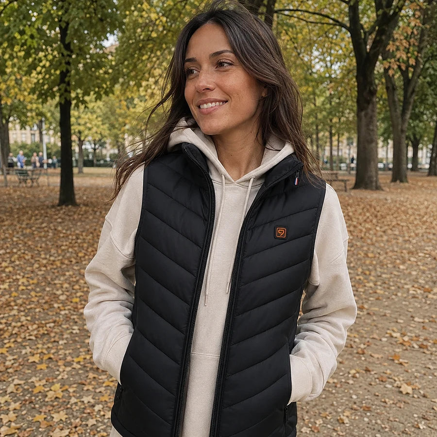 Cliente dans un parc en automne, doudoune chauffante sans manches Ultra 9 ouverte sur un hoodie